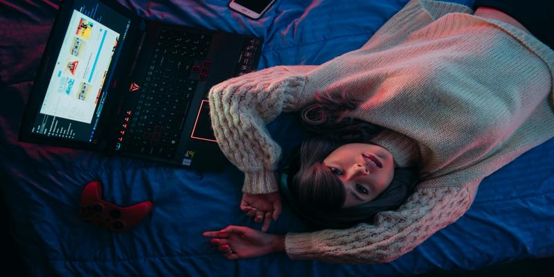 A person lying on a bed with a computer

Description automatically generated